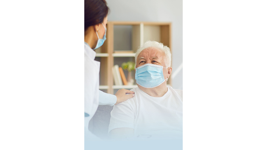 Masked female caregiver supporting masked older man