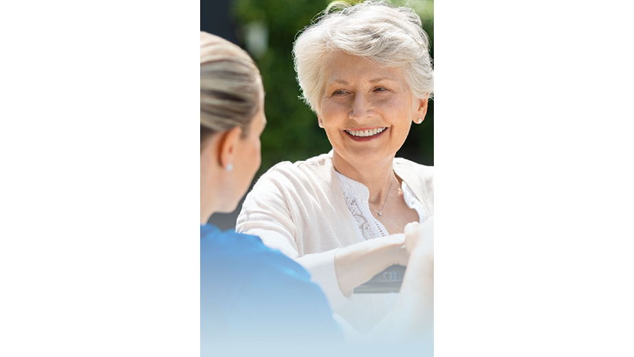 Female caregiver supporting older woman