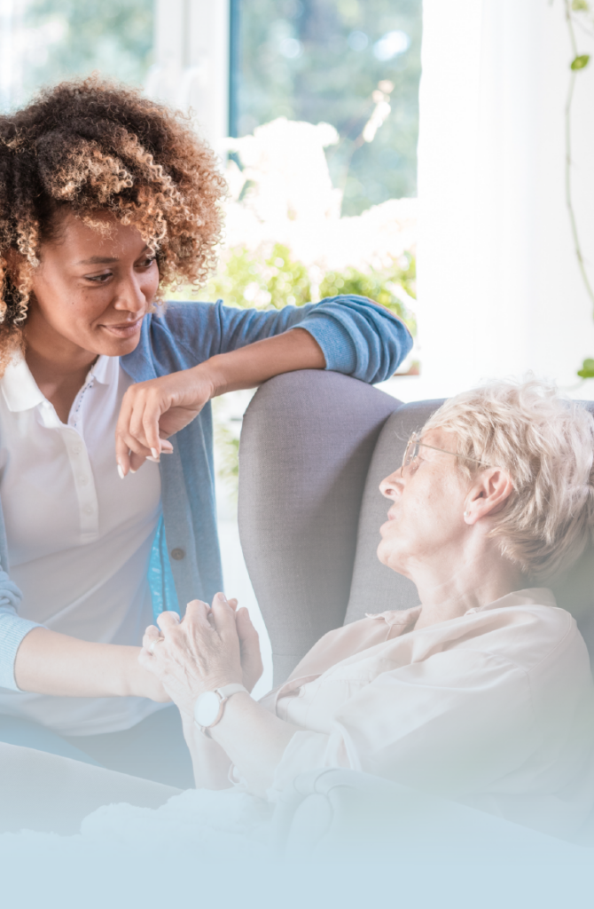 Female caregiver supporting older woman