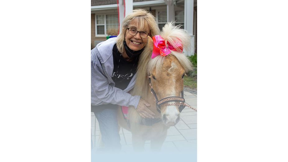Woman smiling with mini horse