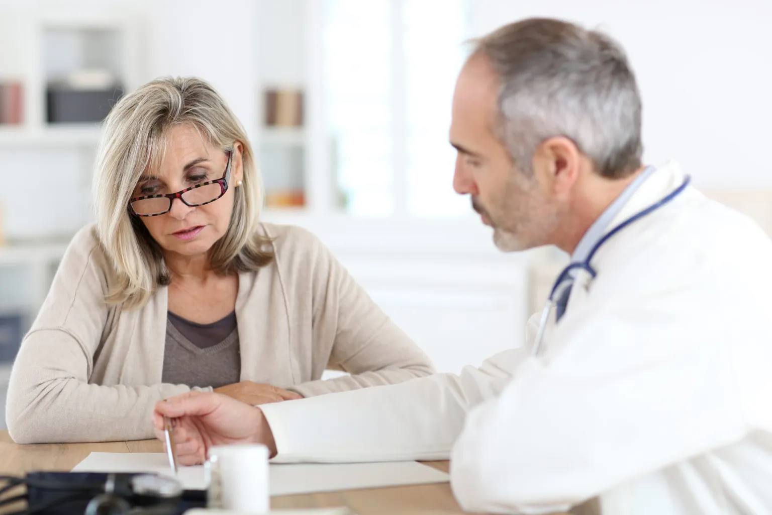 Male doctor speaking with older woman, healthcare, medical support